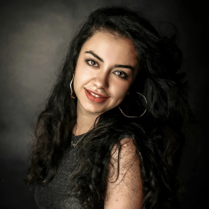 a woman with long black hair smiling at the camera