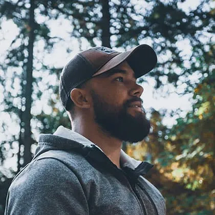 A professional web developer wearing a cap looking away